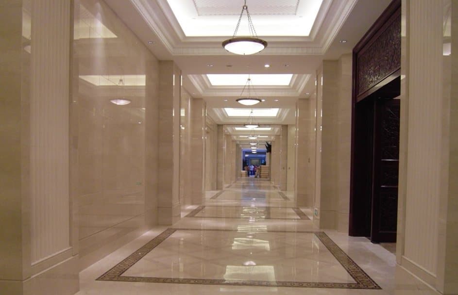 Hotel corridor with cream marble walls and floors